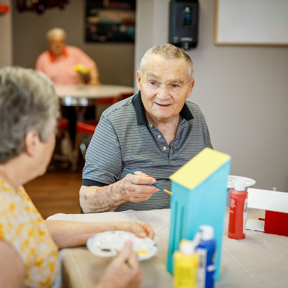 Man working on a craft with friends