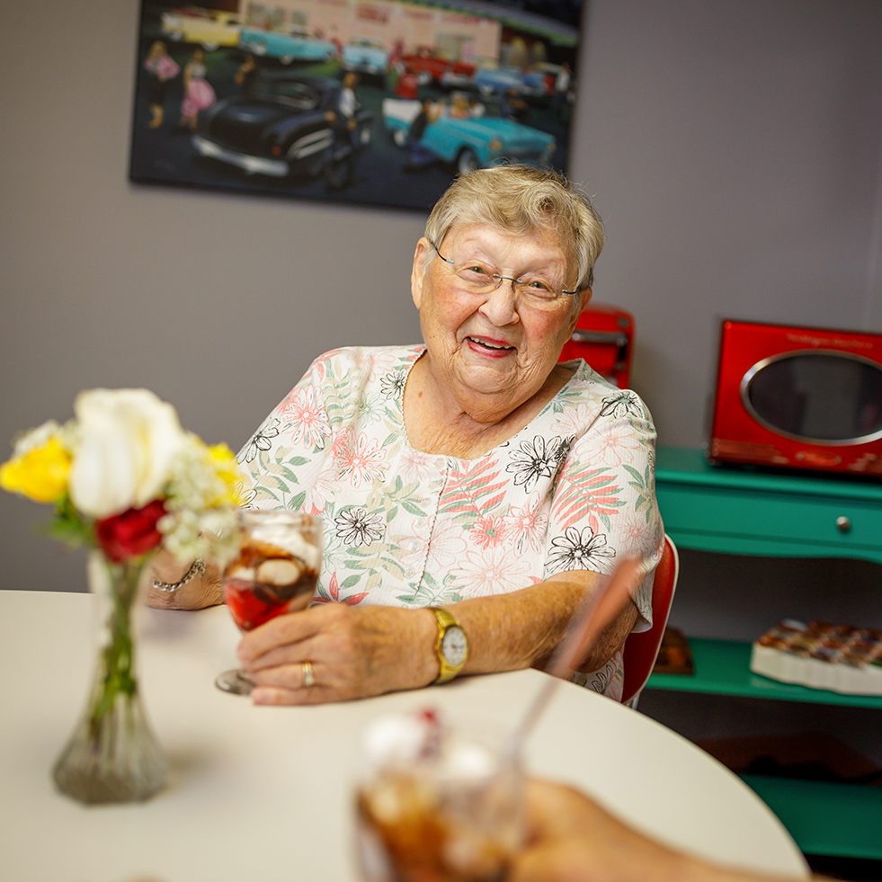 Senior woman smiling while eating ice cream in the "diner"