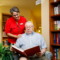 Staff member reading with a male resident in the library