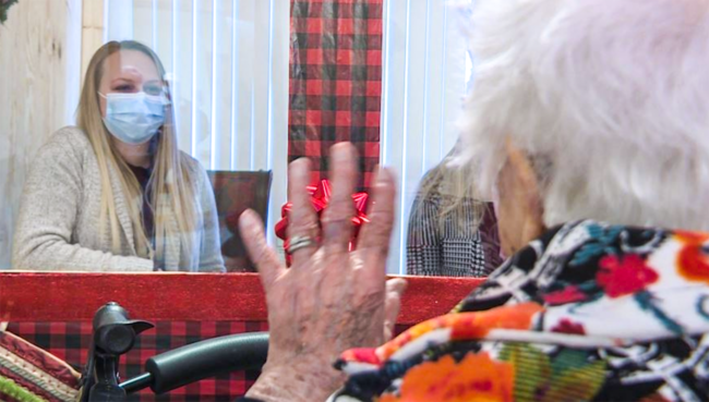 Screen Shot 2020-12-28 at 5.00.48 PM Senior resident waving at her grand daughter at the Heritage House Visiting Booth