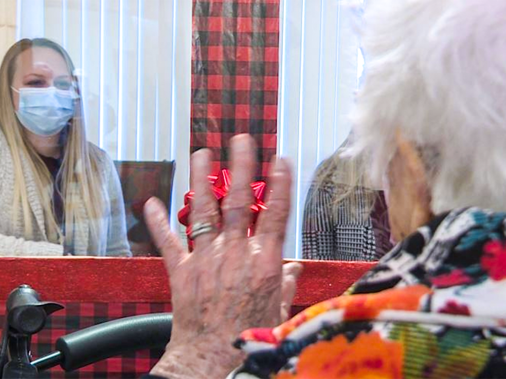 Screen Shot 2020-12-28 at 5.00.48 PM Senior resident waving at her grand daughter at the Heritage House Visiting Booth