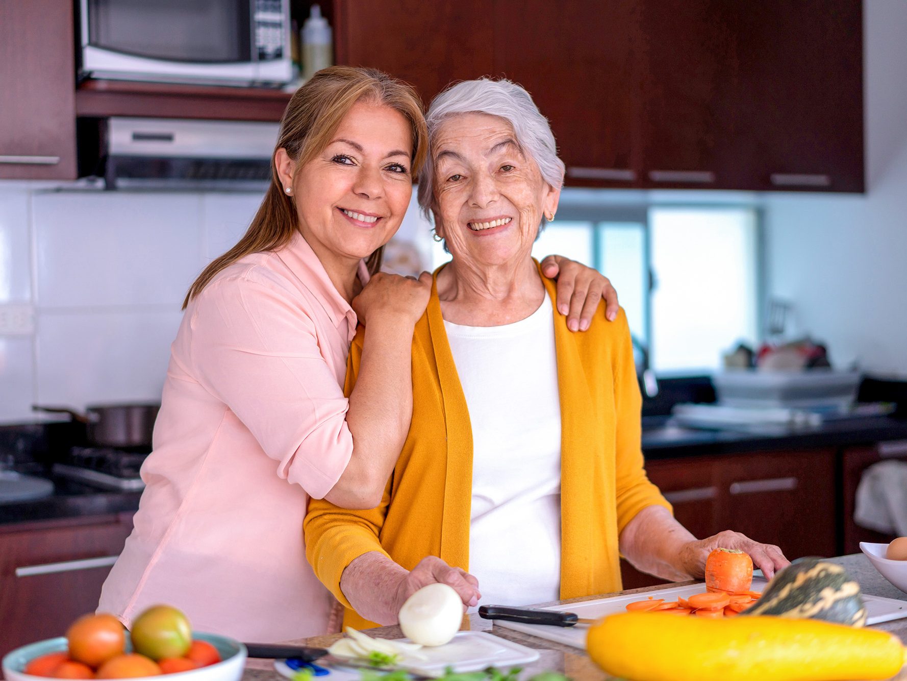 Woman with her senior mother in the kitchen